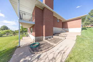 Red brick exterior with white trim and a covered patio