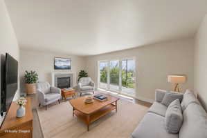 Living area featuring wood-finish flooring, a contemporary fireplace with mantel, and a sliding glass door opening to a balcony