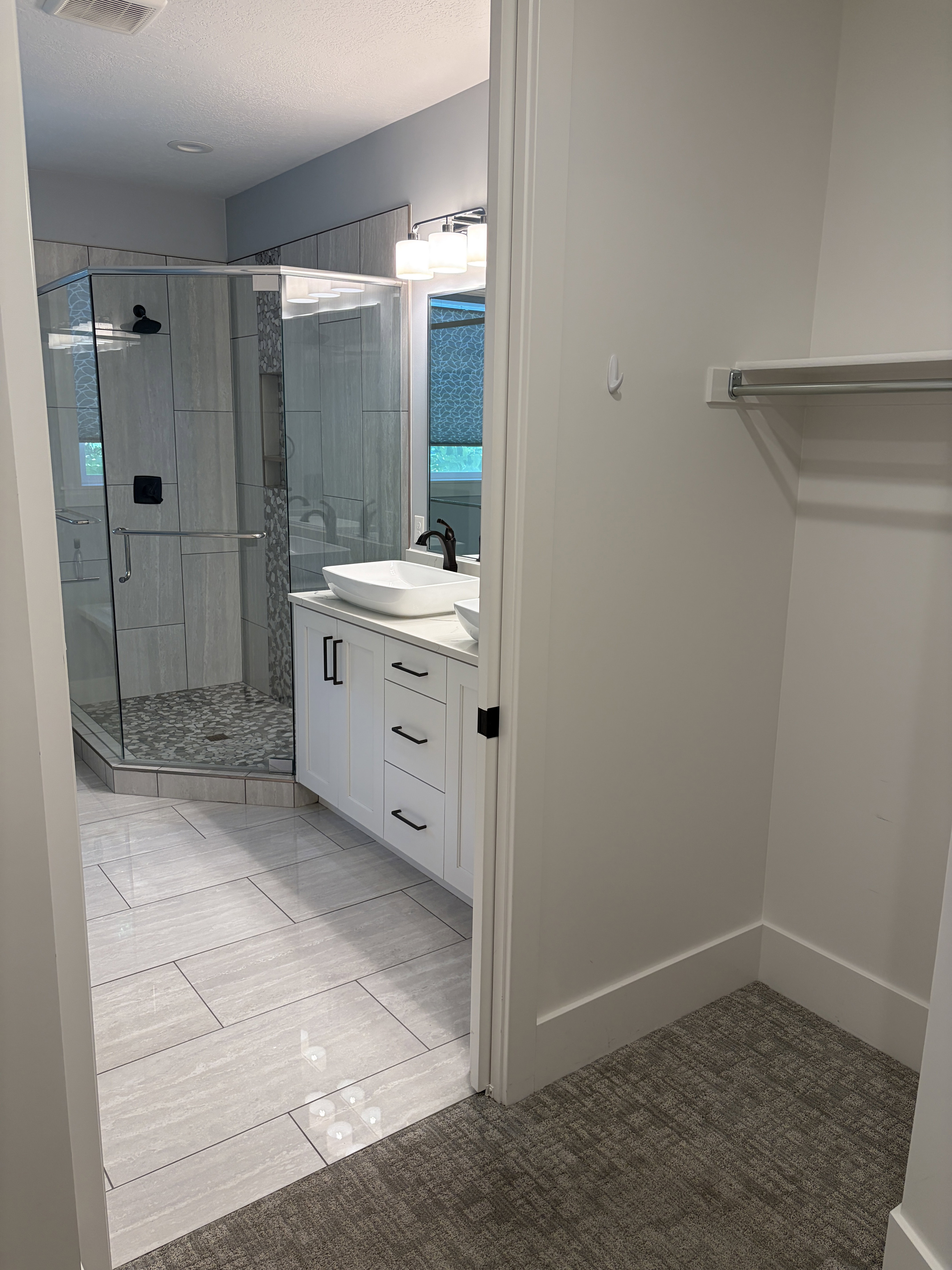 Bathroom featuring a glass-enclosed shower with tiled walls and pebble-style flooring