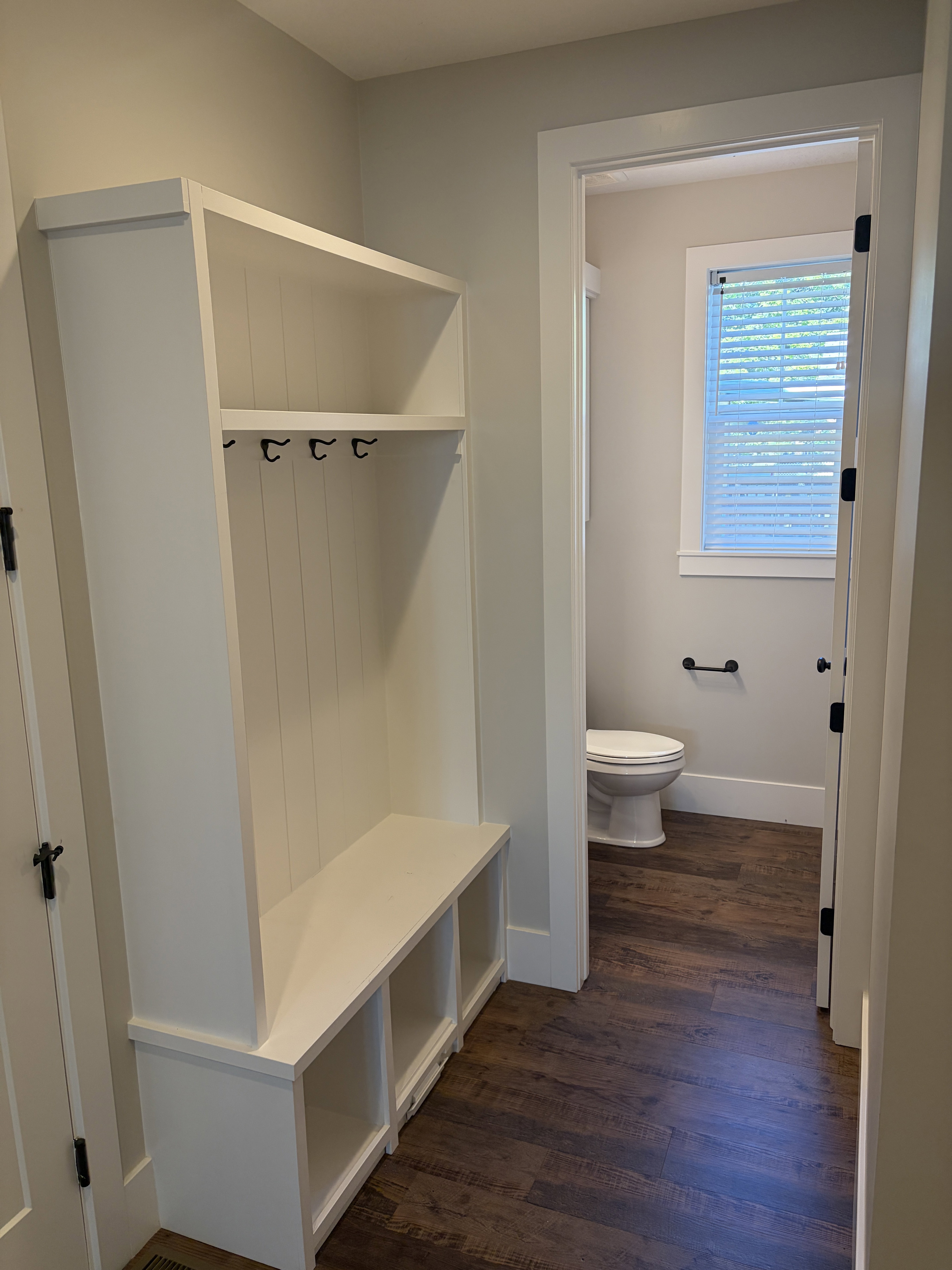 Built-in entryway storage bench with shelving and coat hooks