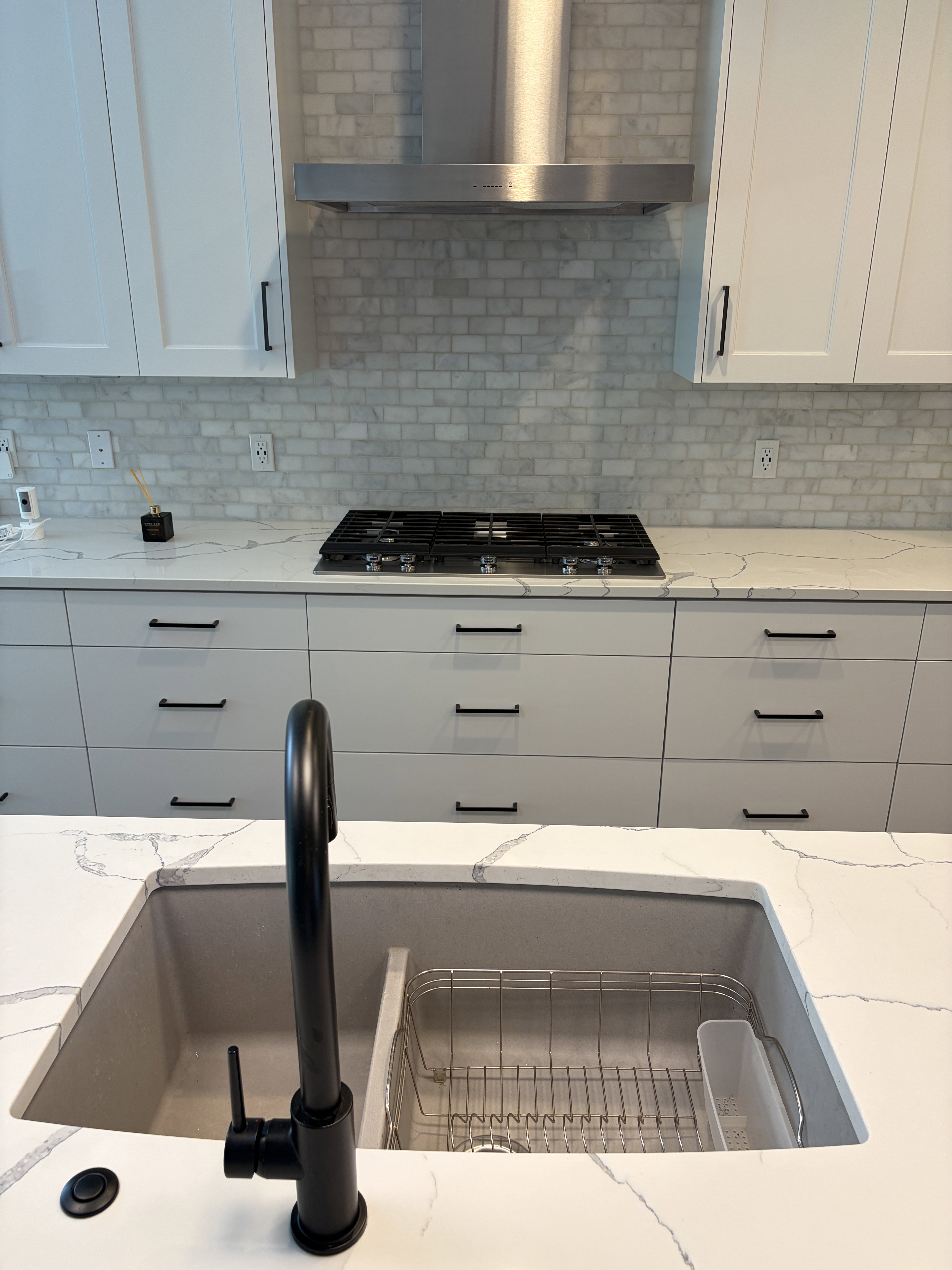 Kitchen featuring white shaker-style upper cabinetry, light gray flat-panel lower cabinetry, and a subway tile backsplash