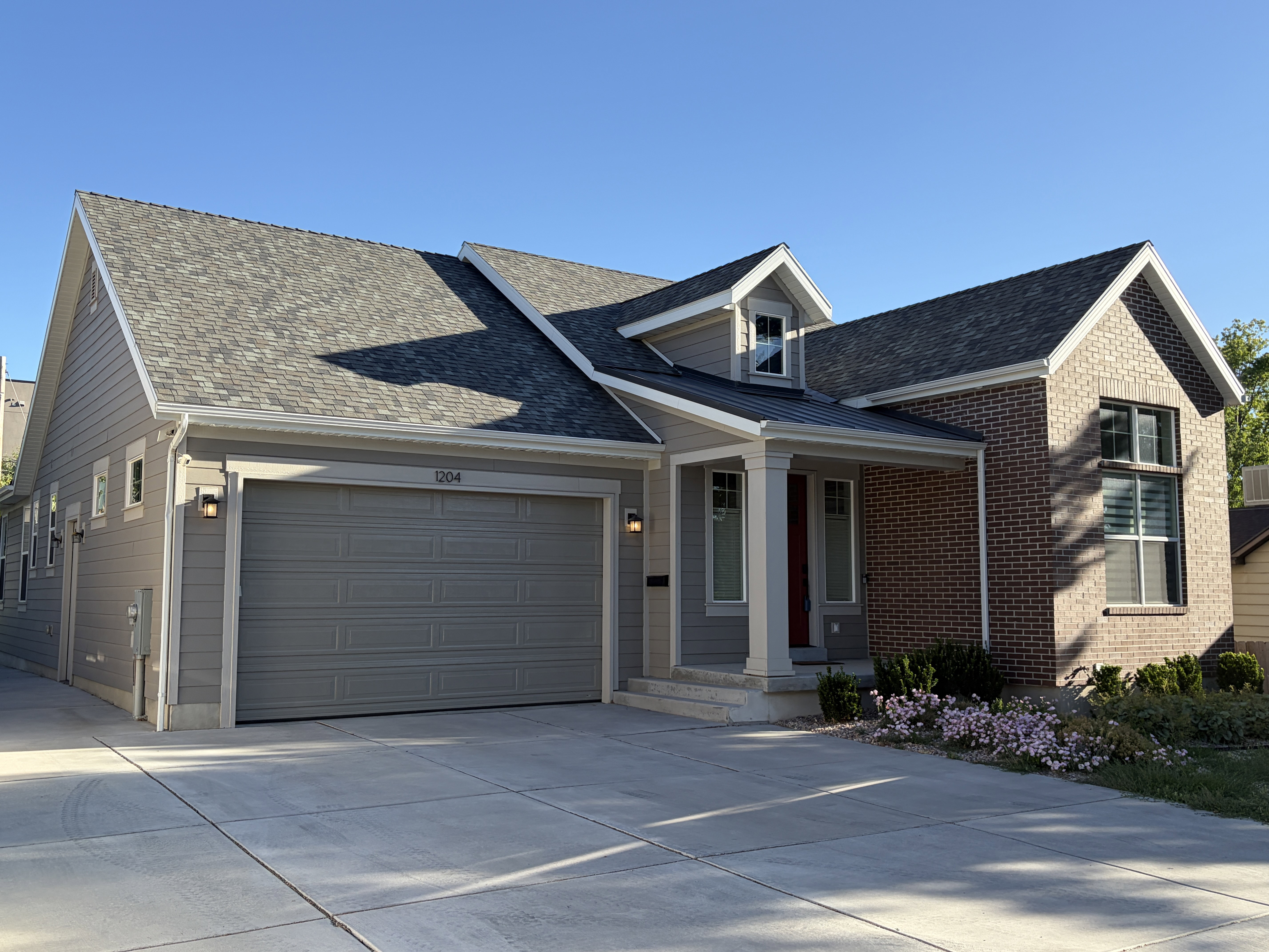 Contemporary exterior featuring a brick facade and gray siding