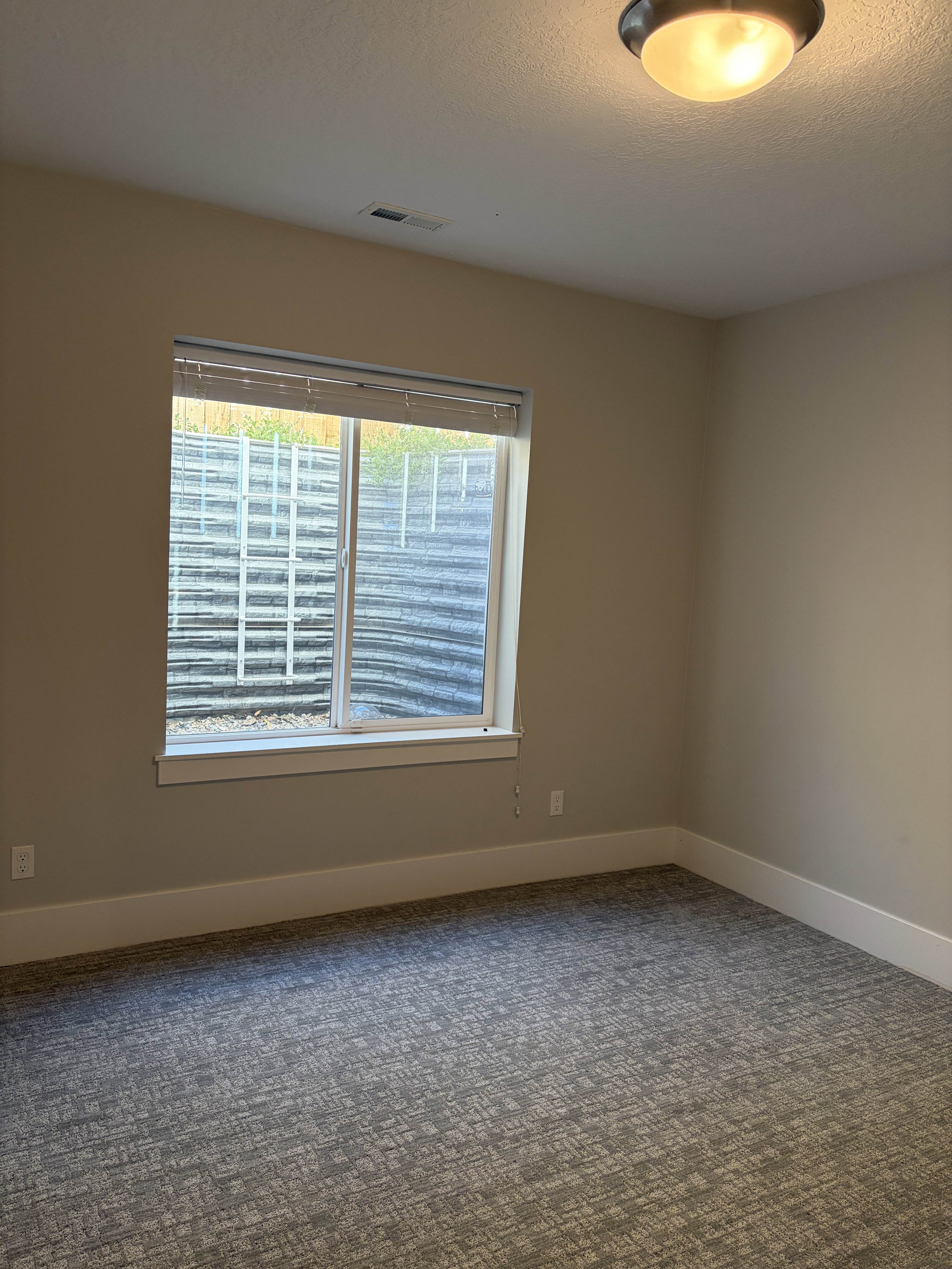Room featuring neutral wall tones and patterned carpeting