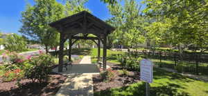 Wood gazebo with built-in benches, set on a concrete pathway
