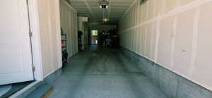 Spacious garage featuring a concrete floor, exposed drywall walls, and overhead lighting