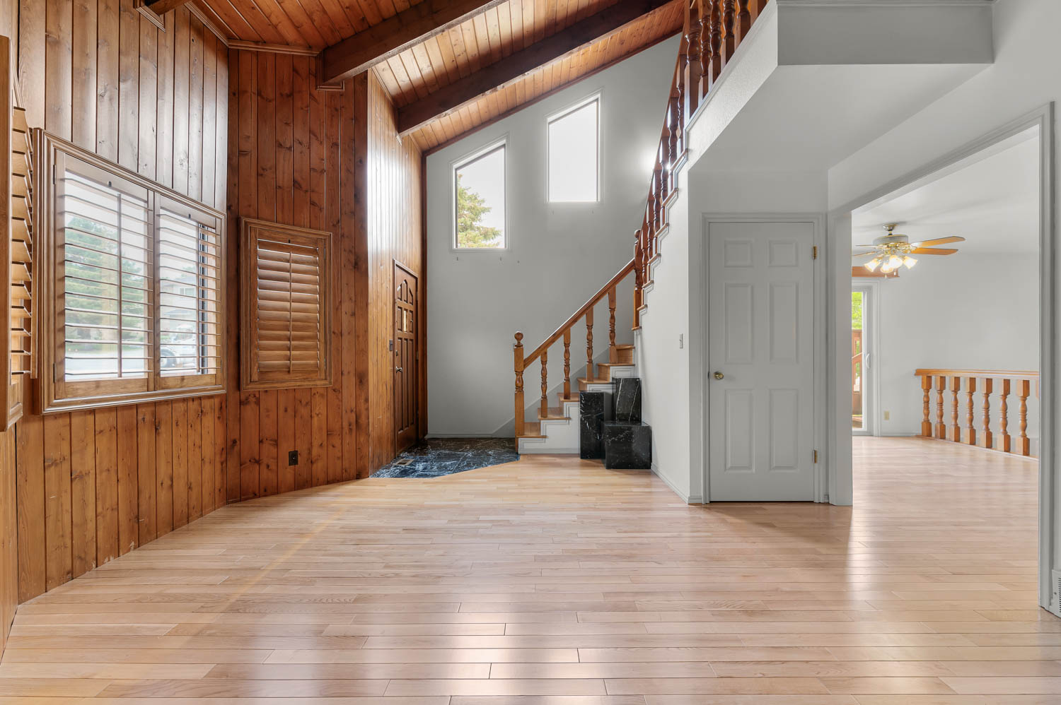 Entryway and living room with vaulted ceilings- unstaged