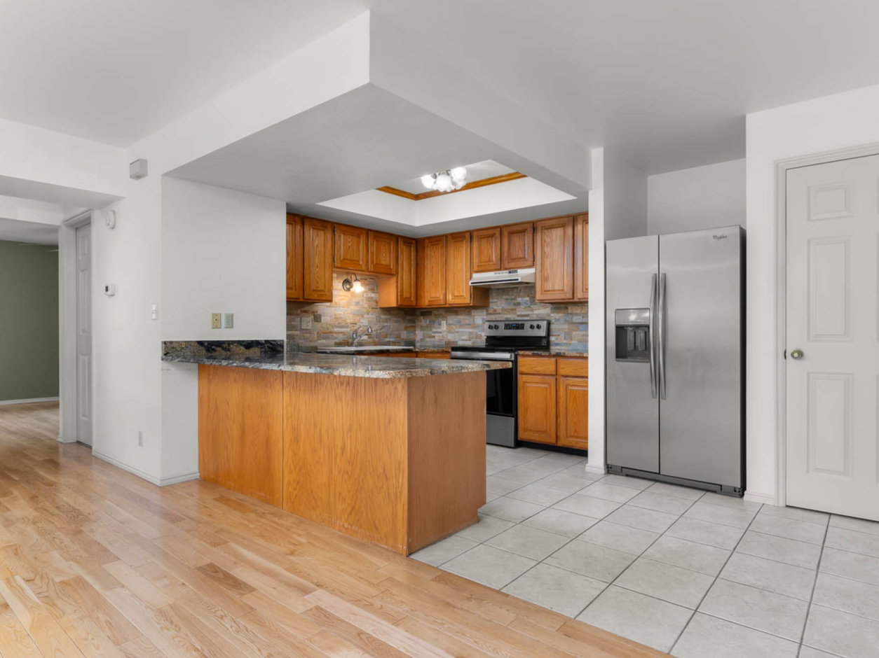 Kitchen featuring granite countertops and stainless steel appliances- unstaged