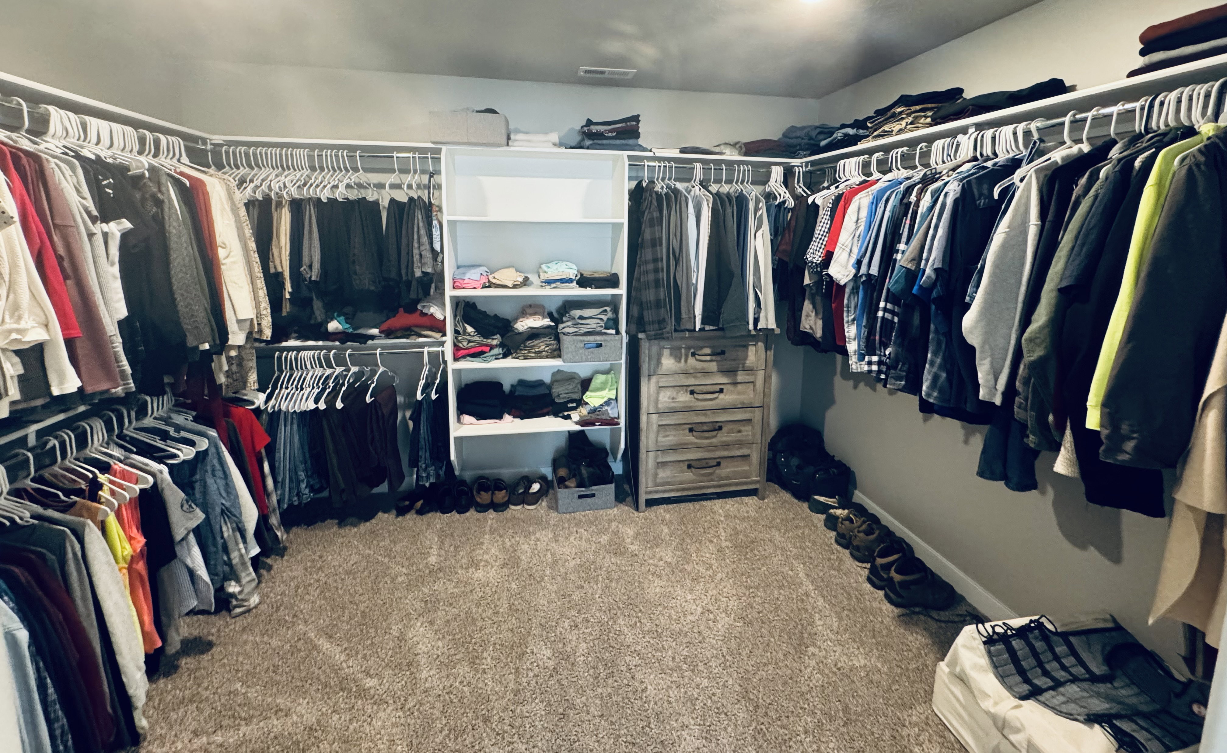 Spacious walk-in closet featuring extensive built-in shelving and hanging rods