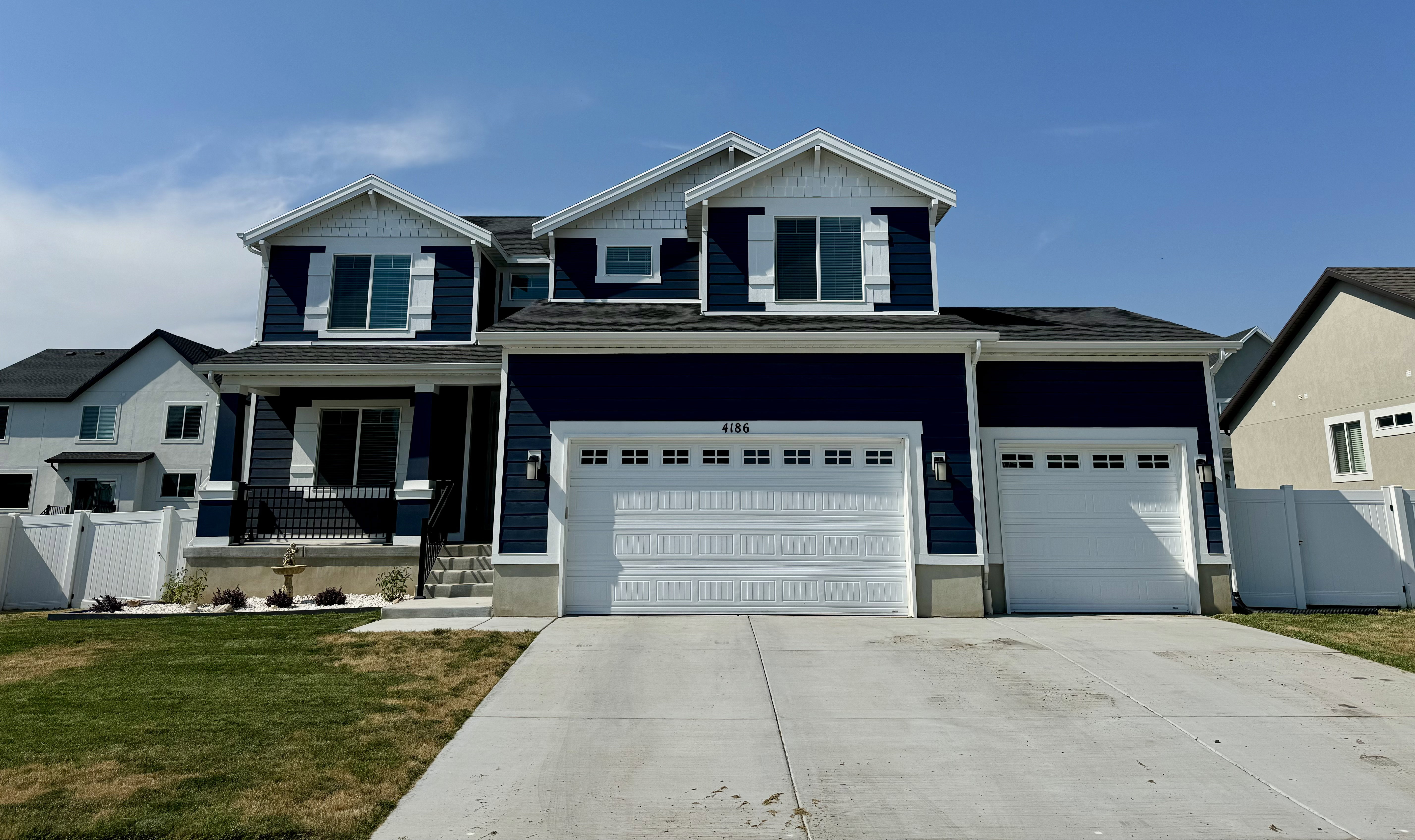 Two-story residence featuring deep blue siding and white trim