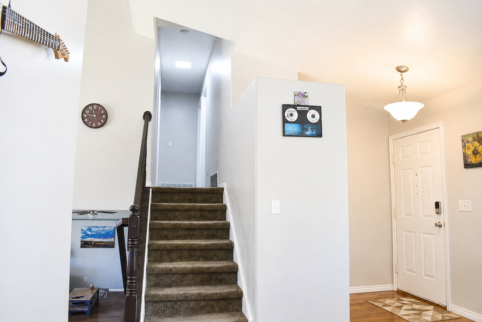 Carpeted staircase with dark wood banister