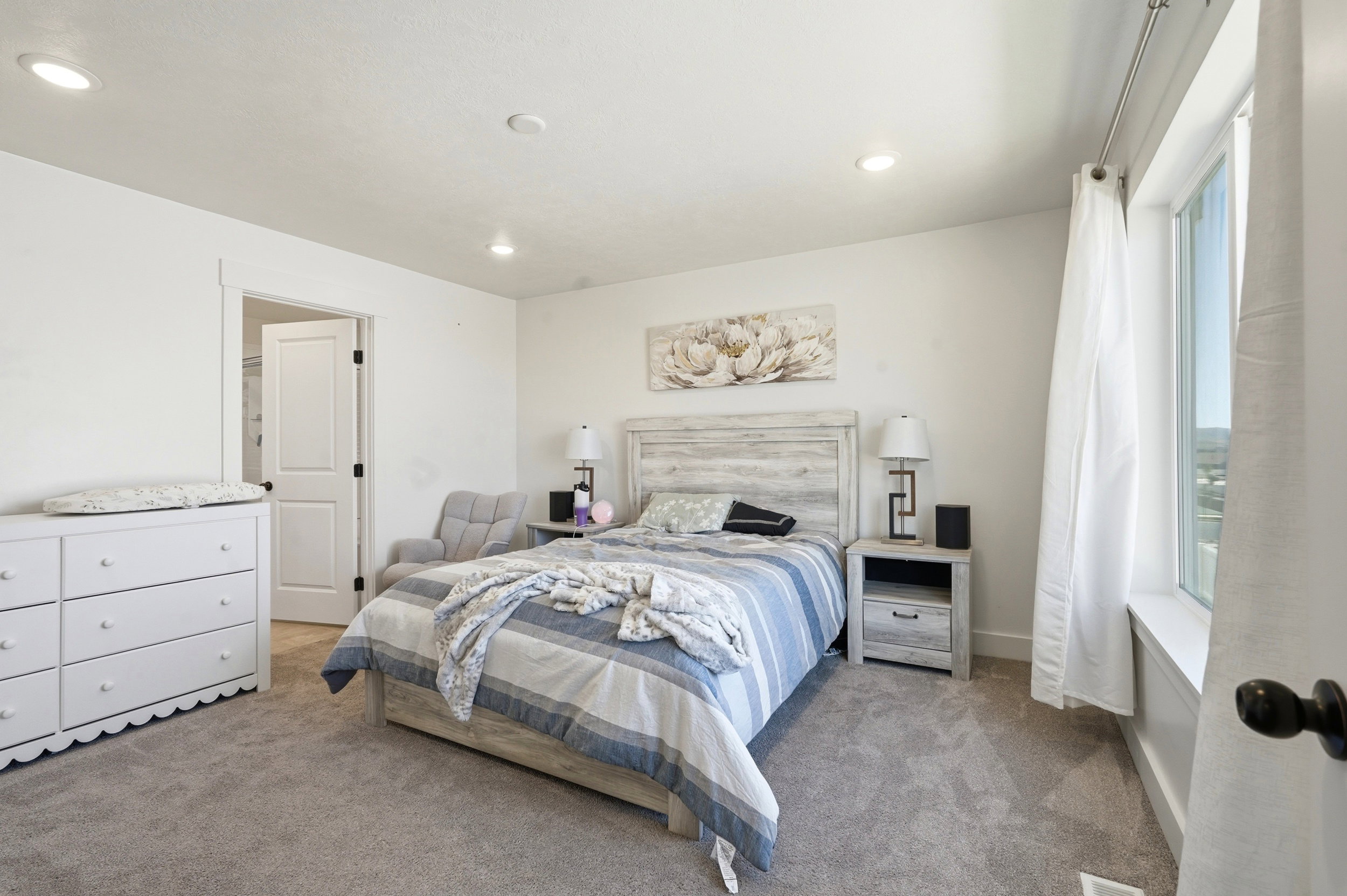 Carpeted bedroom featuring recessed lighting and a window with white trim