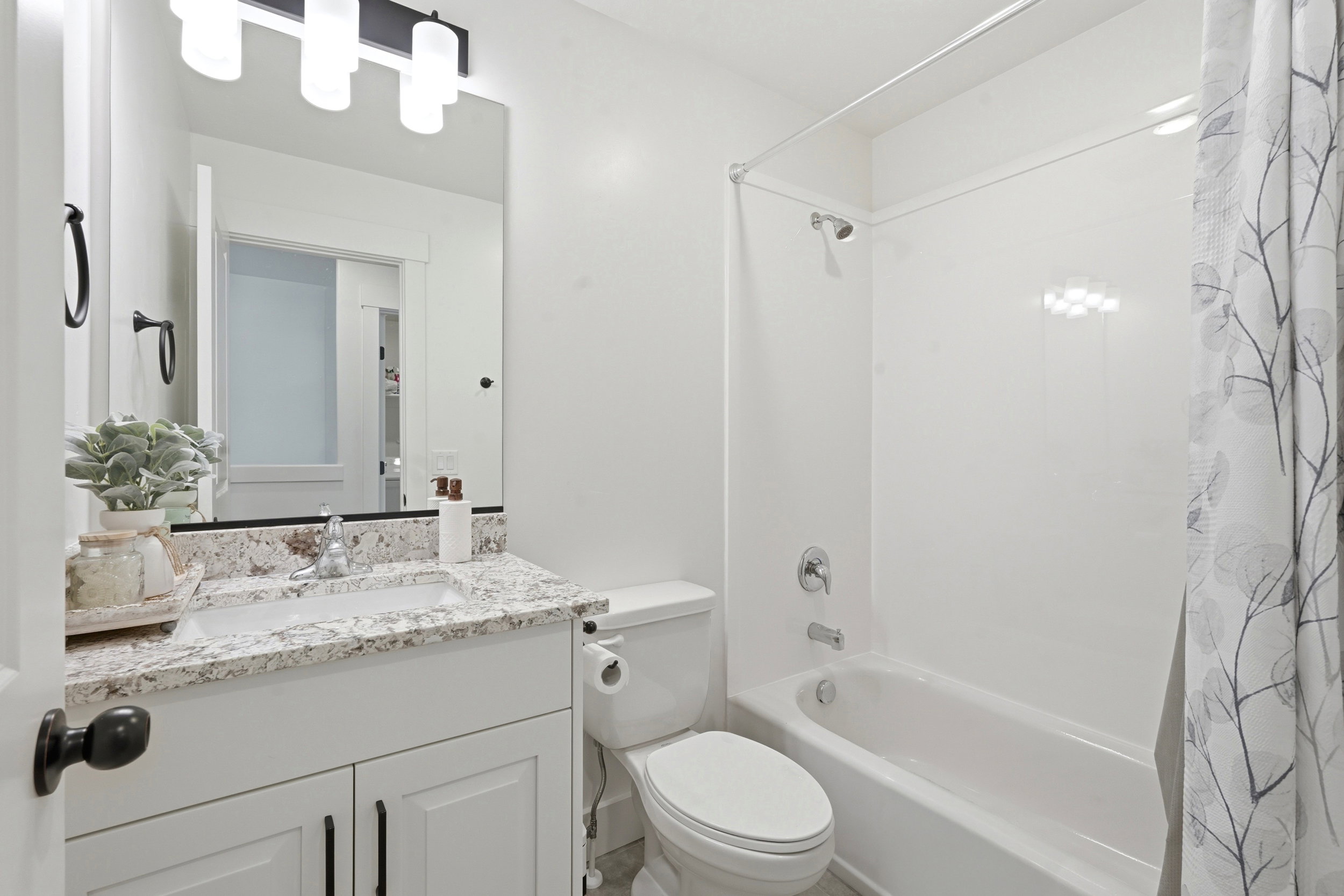 Bathroom featuring a white vanity with a speckled countertop and an undermount sink