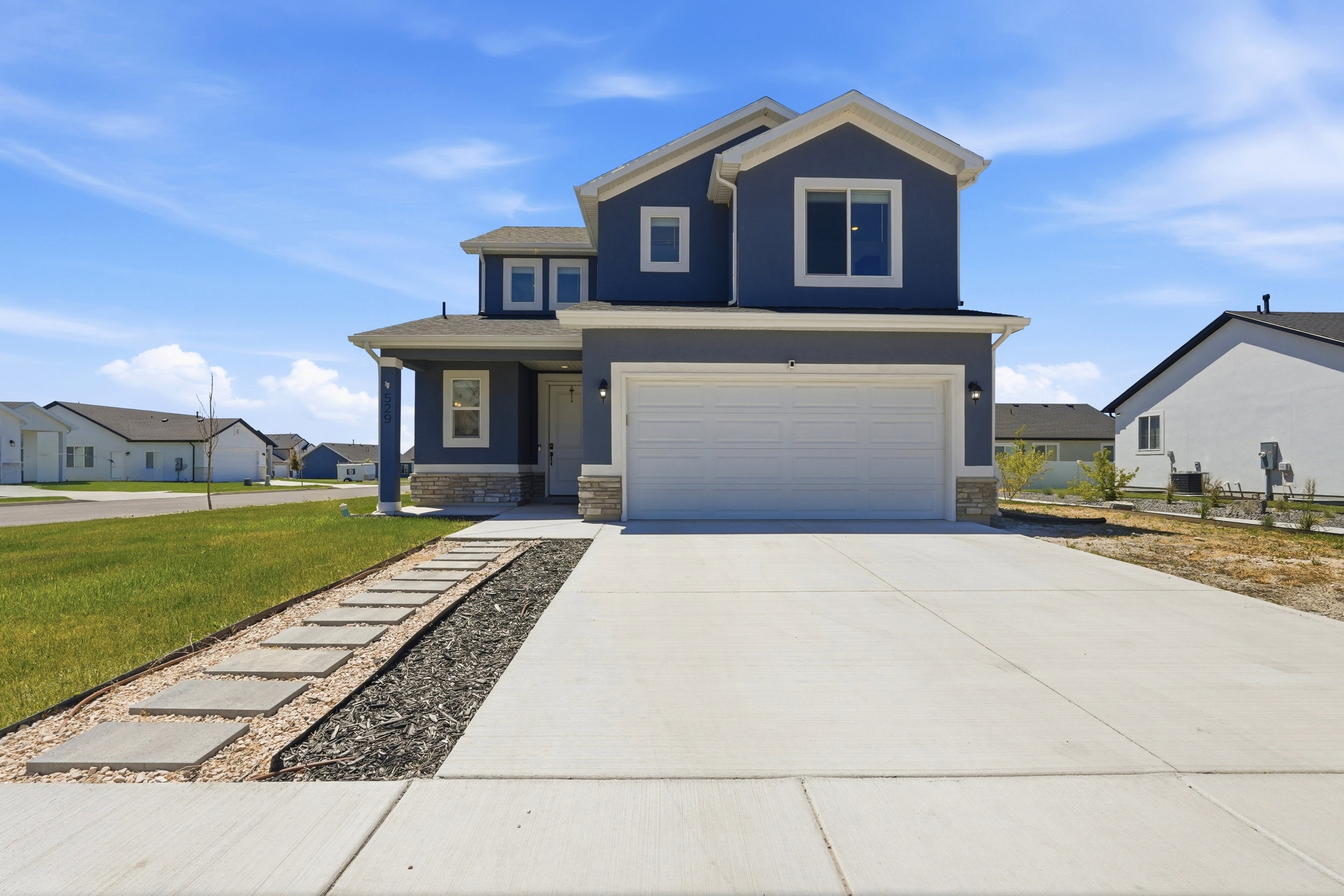 Contemporary two-story residence featuring a blue exterior and white trim accents