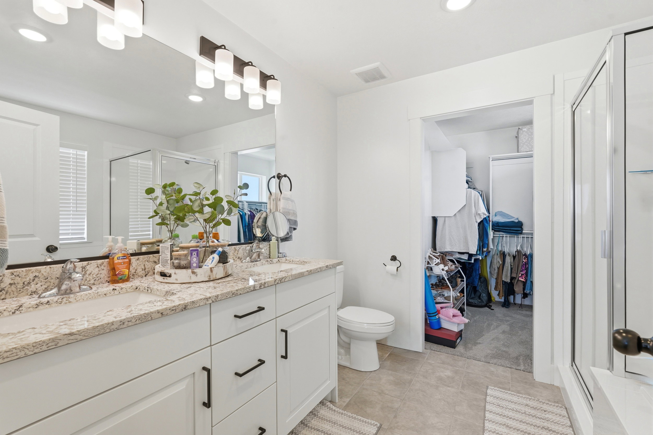 Double vanity with stone countertop, dual sinks, and matte black hardware