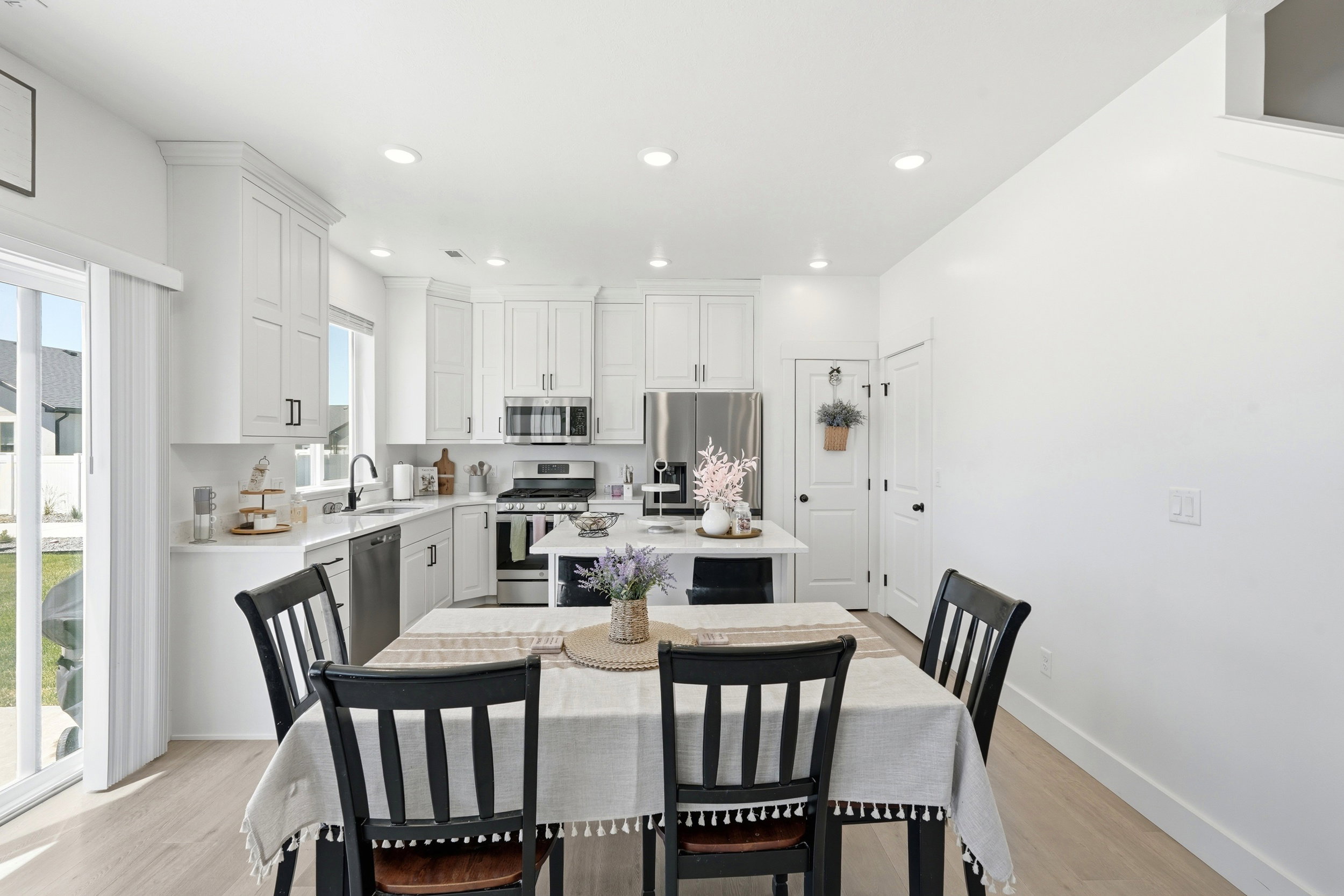 Modern kitchen featuring white cabinetry, stainless steel appliances, a center island with countertop seating, recessed lighting, and light wood-finish flooring