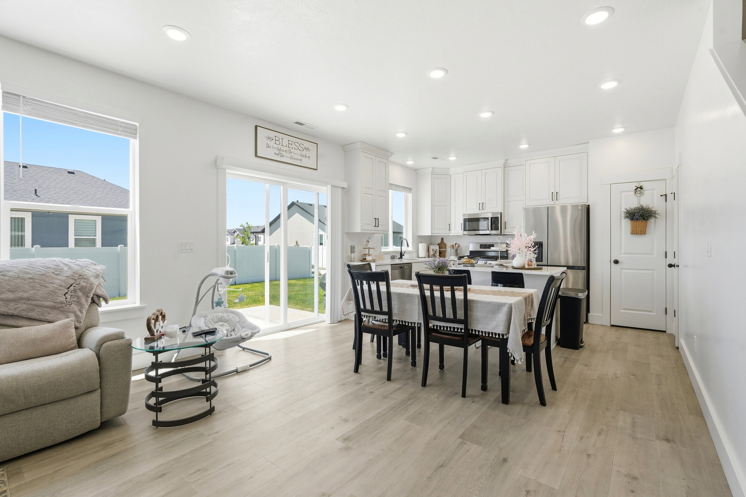 Bright open-concept living area featuring light wood-finish flooring and recessed lighting