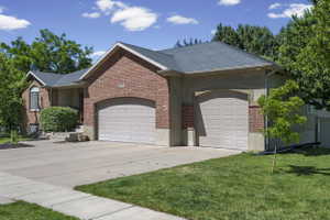 Brick and stucco exterior with a dark shingle roof