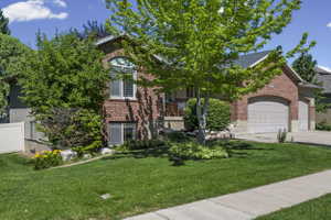 Brick exterior with an arched window, white window shutters, and a two-car garage
