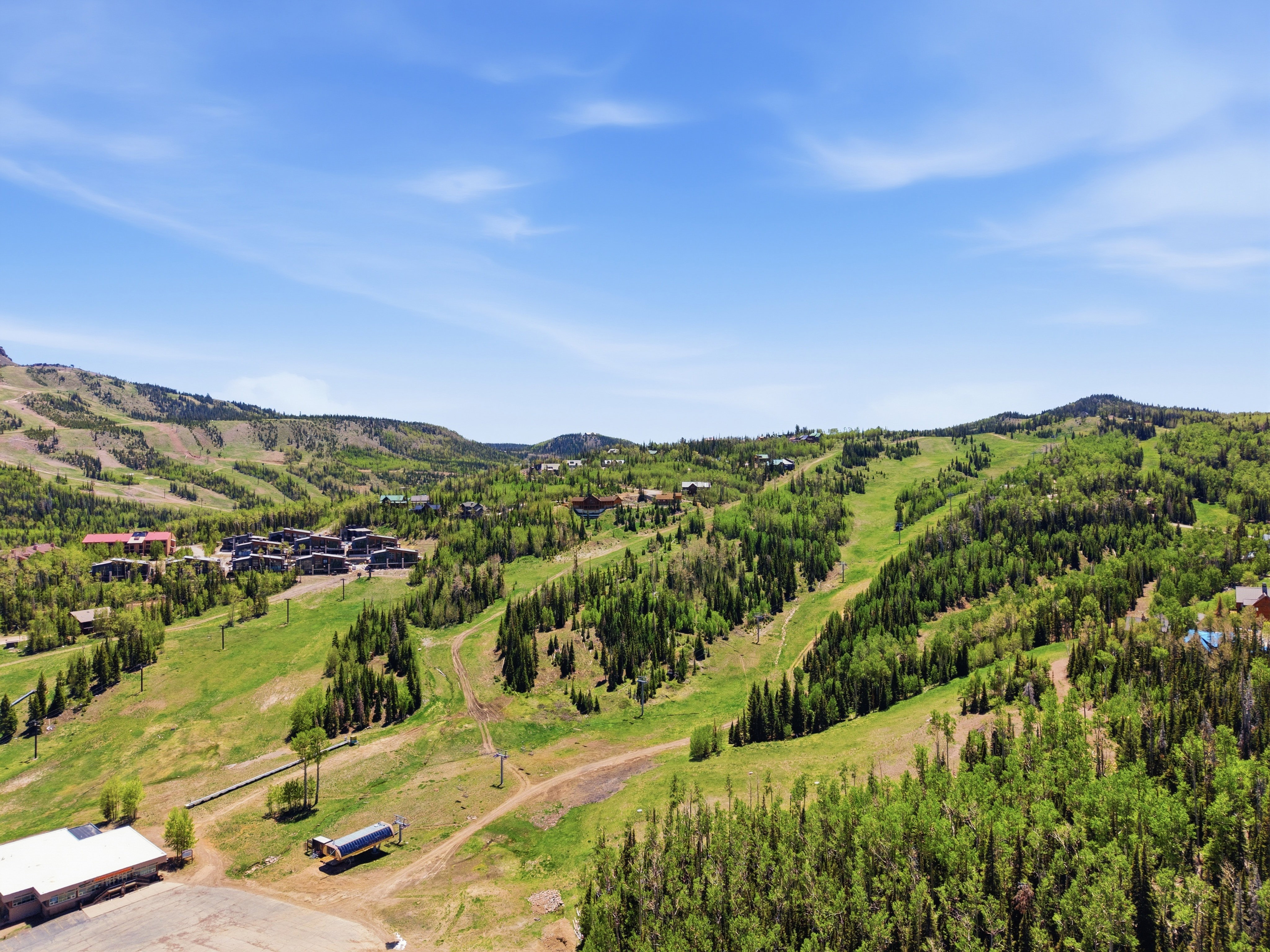 Expansive mountain landscape featuring ski slopes and dense evergreen tree coverage