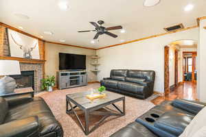Living area featuring a brick fireplace, wood mantel, recessed lighting, and a ceiling fan