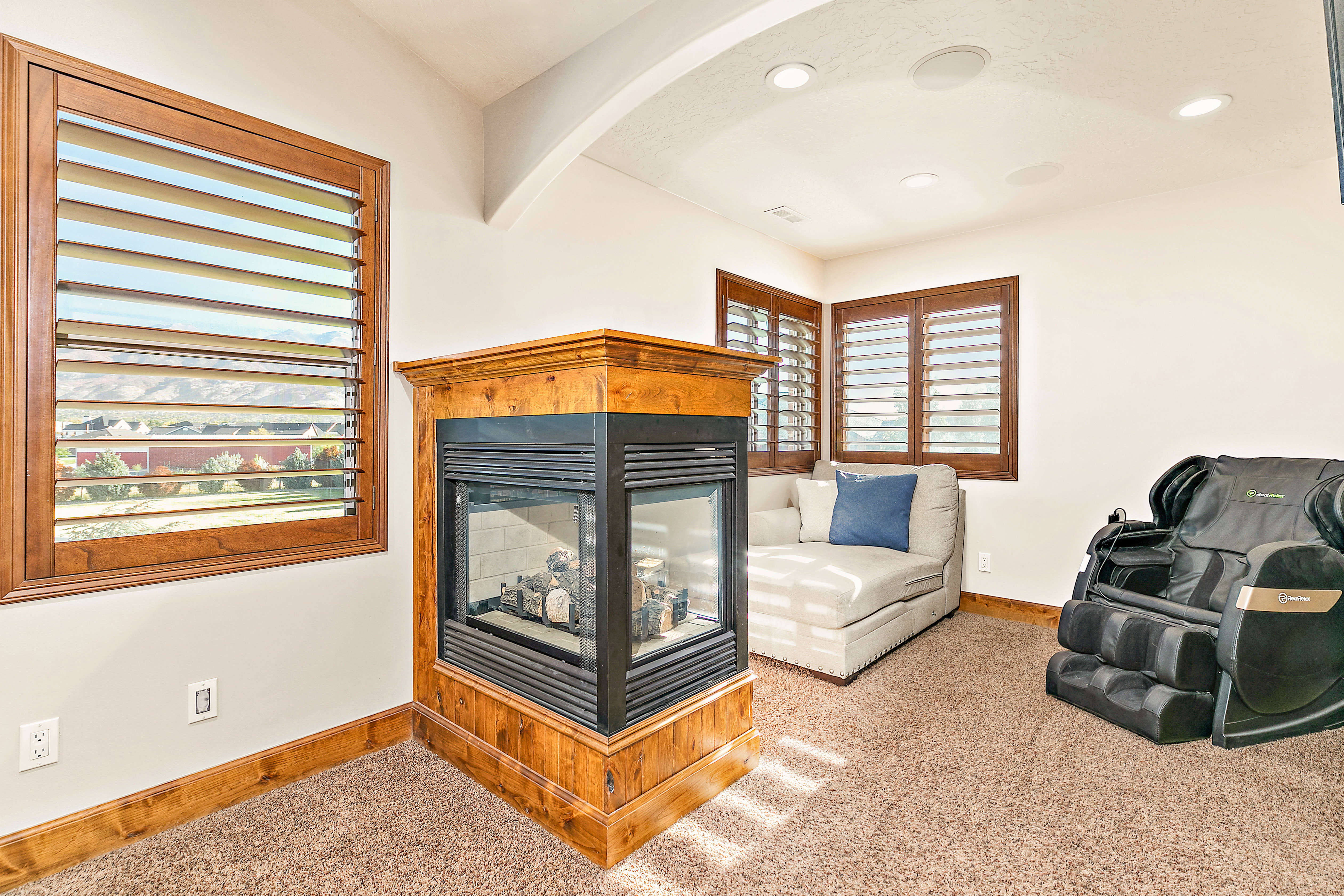 Corner fireplace featuring a wood surround and a glass-front insert