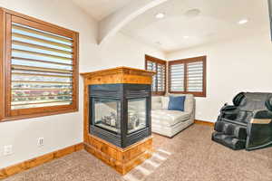 Corner fireplace featuring a wood surround and a glass-front insert