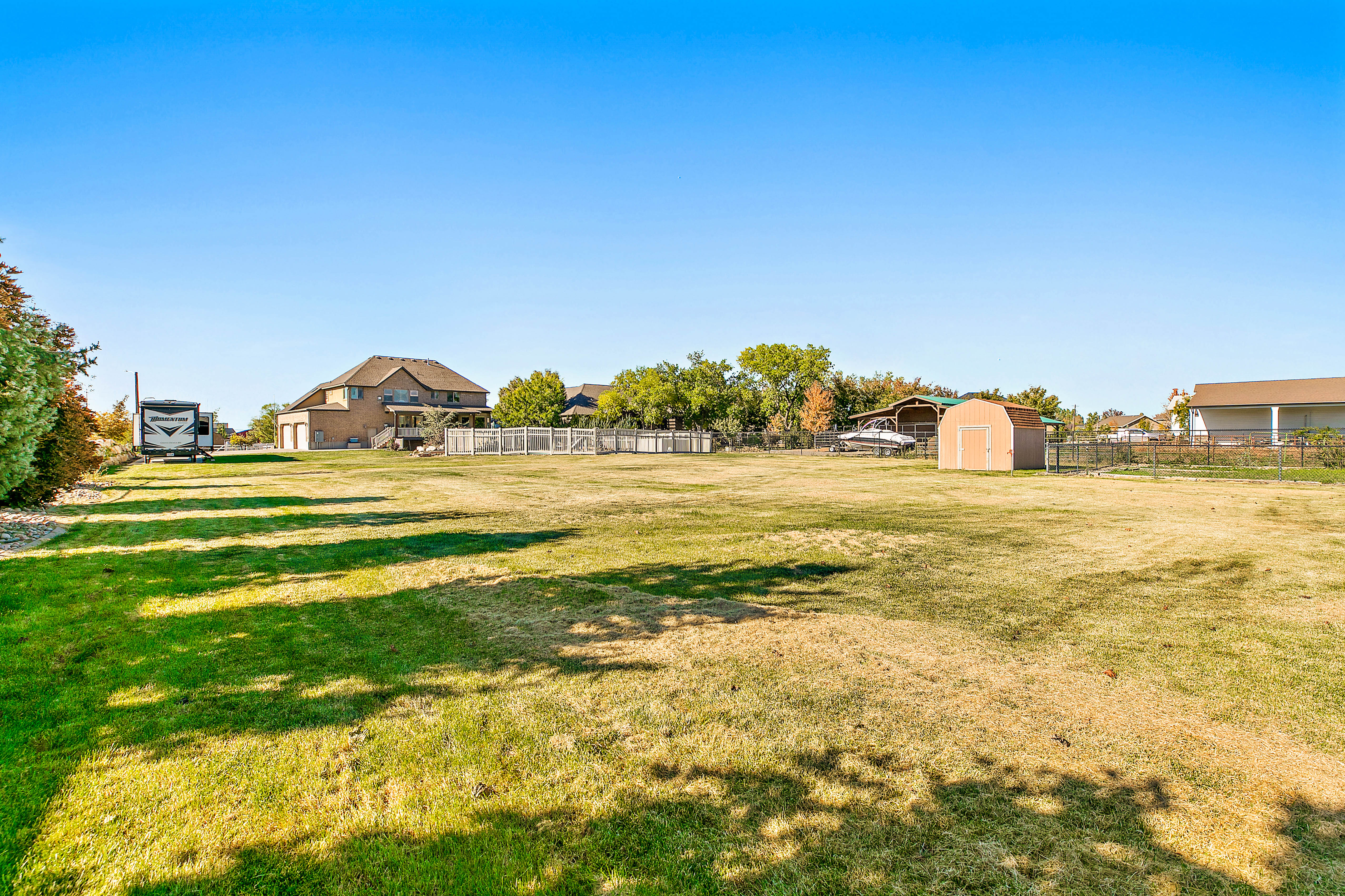 Expansive grassy area featuring a detached storage shed