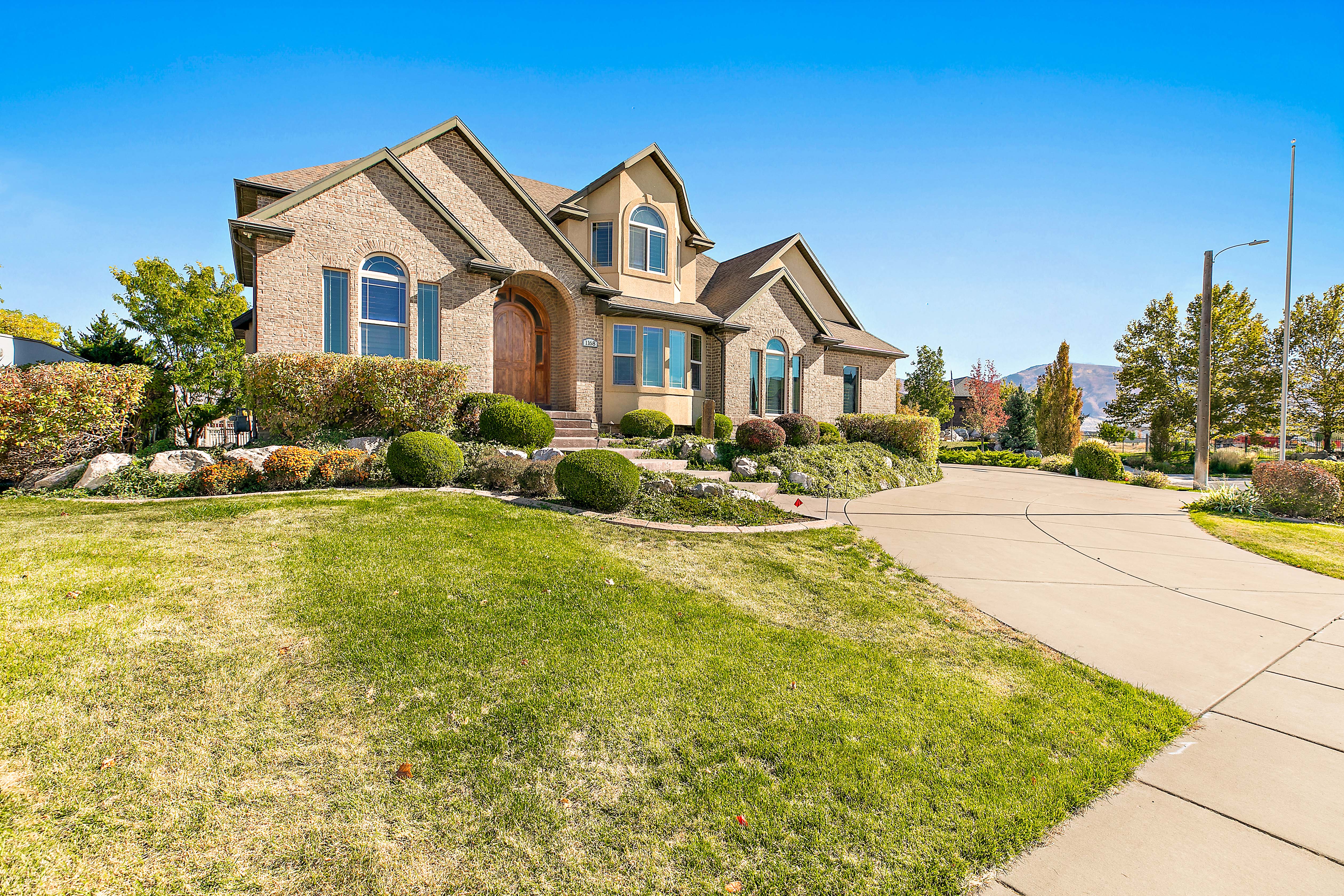 Brick and stucco exterior featuring multiple gables and arched windows