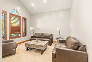 Living area featuring high vaulted ceilings, recessed lighting, and a neutral wall color
