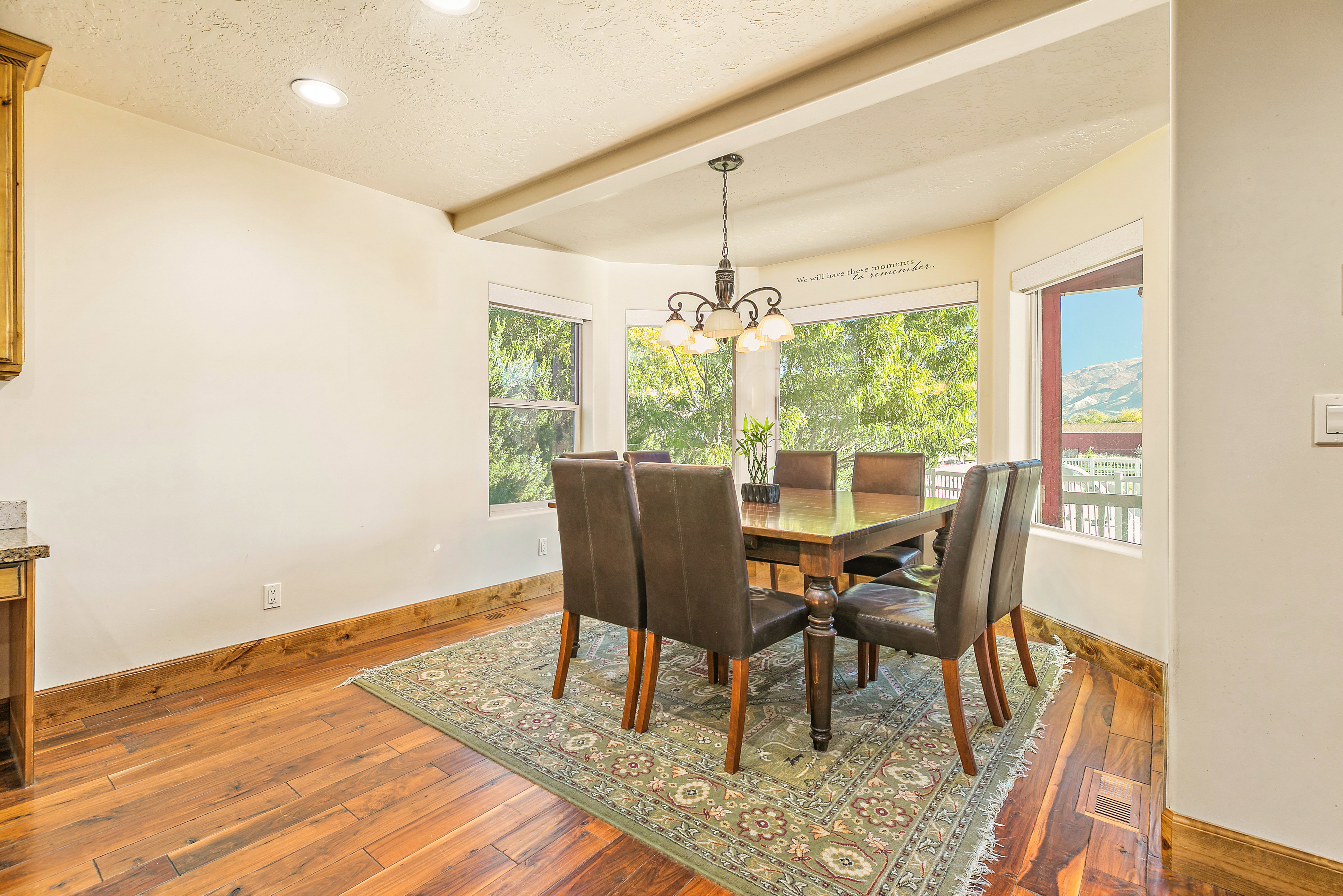 Bay window dining area featuring wood-finish flooring, recessed lighting, and a decorative chandelier