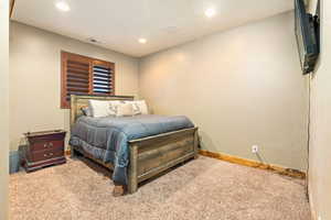 Plush carpeted room featuring a window with wood plantation shutters