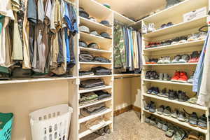Custom closet system featuring multiple hanging rods, extensive shelving, dedicated shoe storage, and integrated corner units