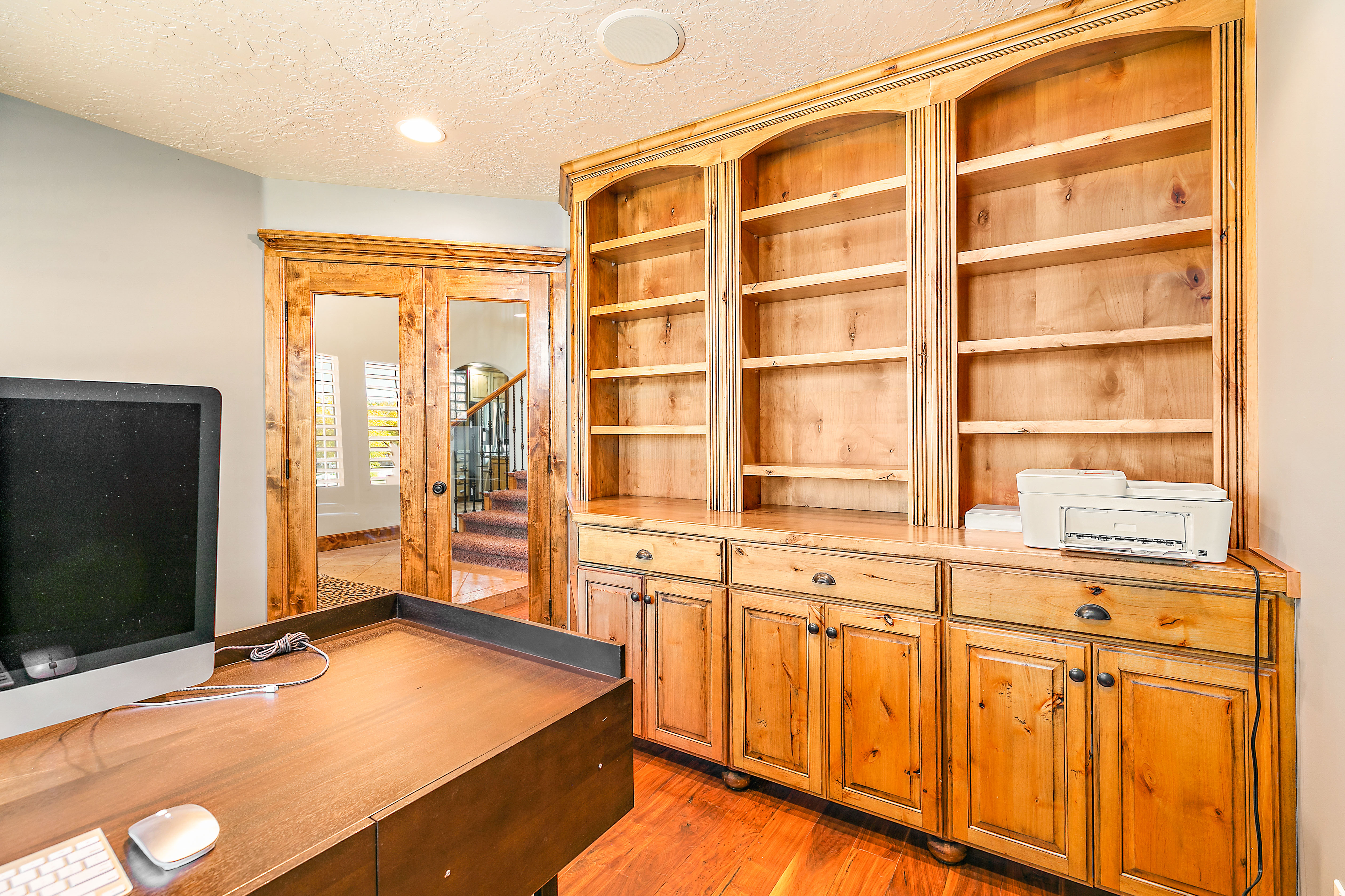 Built-in wood cabinetry featuring arched shelving and lower storage cabinets with drawer pulls
