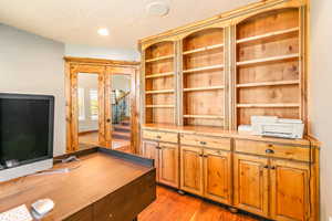 Built-in wood cabinetry featuring arched shelving and lower storage cabinets with drawer pulls