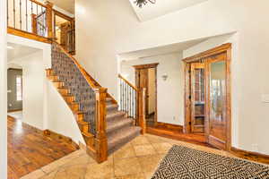 Grand entryway featuring a staircase with wood treads, carpeted steps, and wrought iron balusters