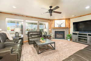 Living area featuring a brick fireplace with wood mantel, wood-finish accent wall, and multiple windows