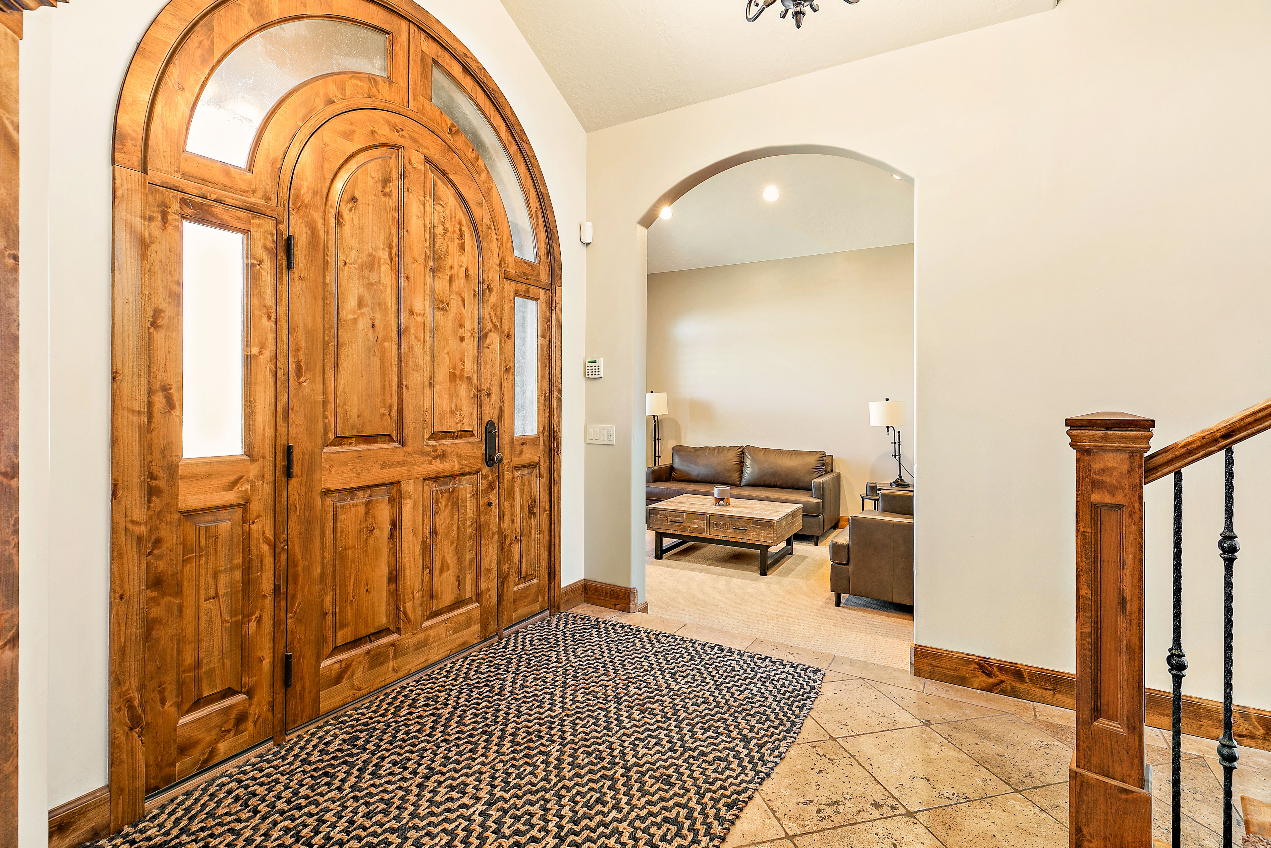 Grand arched wood entry doors with transom and sidelight windows