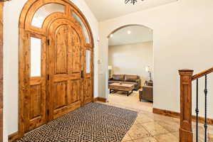 Grand arched wood entry doors with transom and sidelight windows