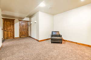 Carpeted room featuring recessed lighting, two panel doors with detailed wood trim, and wall-mounted sconces