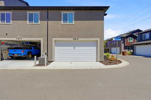 Contemporary stucco exterior with a white panel garage door