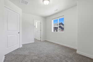 Room featuring light gray carpeting, crisp white walls, and a recessed window