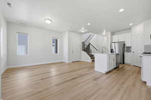 Open-concept living space with light wood-finish flooring