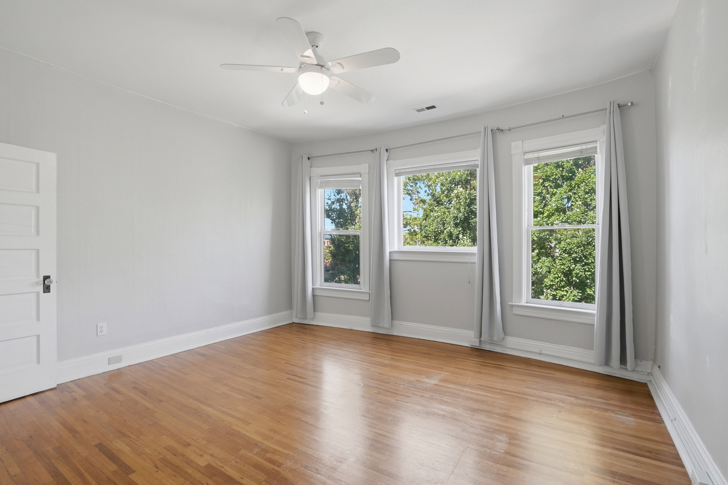 Hardwood flooring complemented by white trim and light gray walls