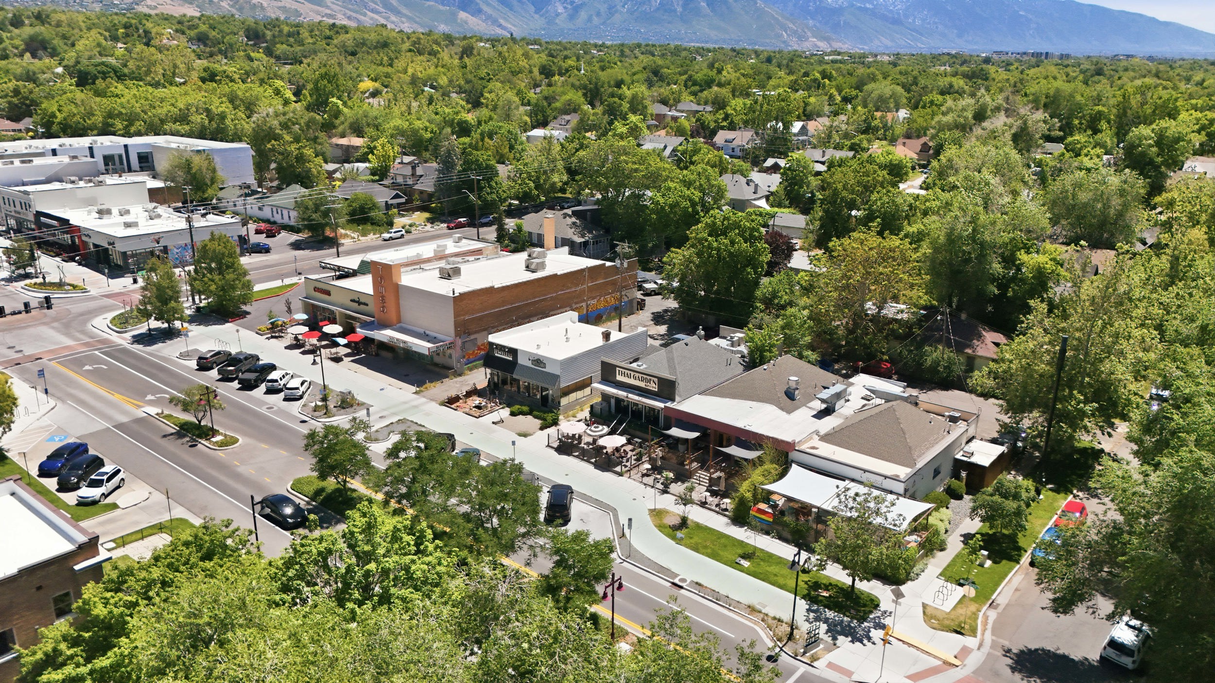 Aerial perspective showcasing a vibrant commercial district with multiple storefronts and street-level dining options