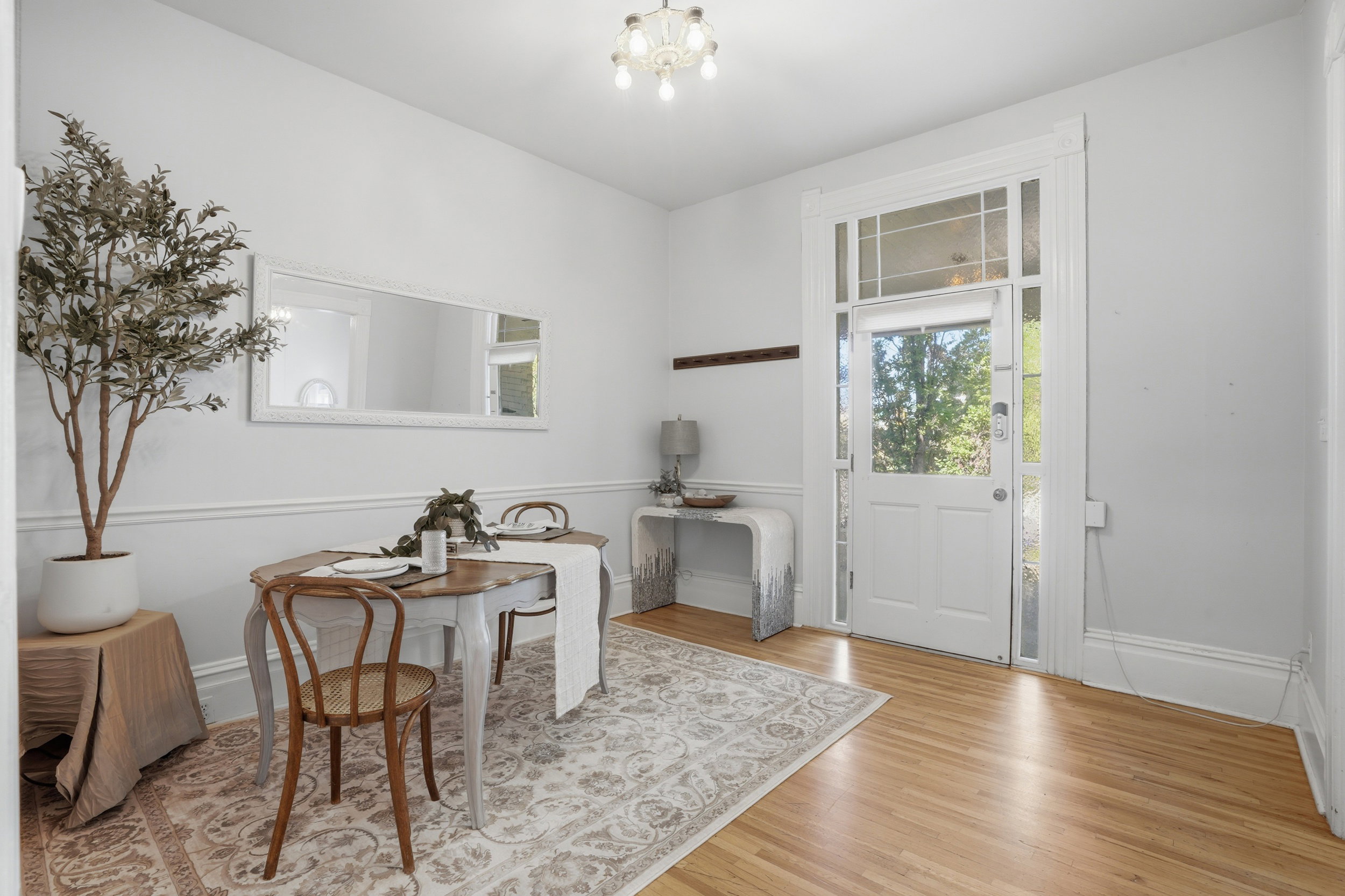 Light wood-finish flooring complements the white wainscoting and trim