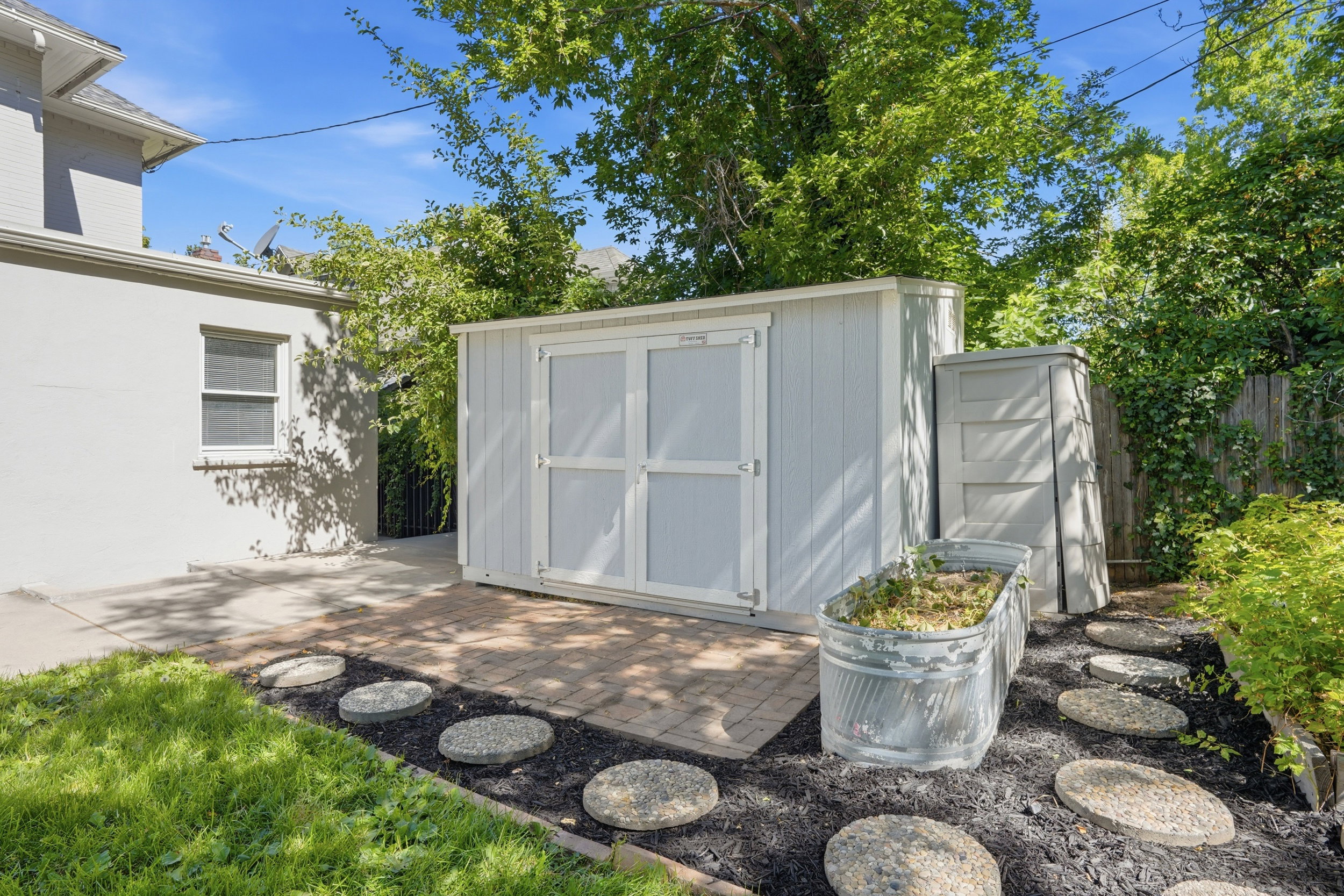 Outdoor storage shed positioned on a brick paver patio