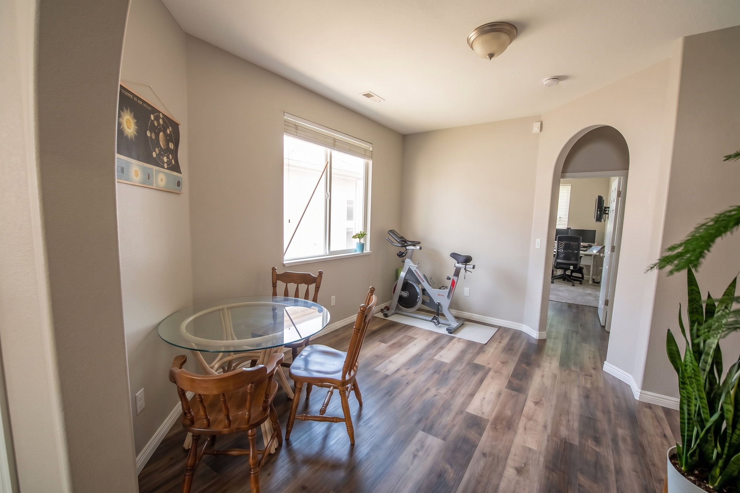 Dining room with arched walkways and dark wood-style floors