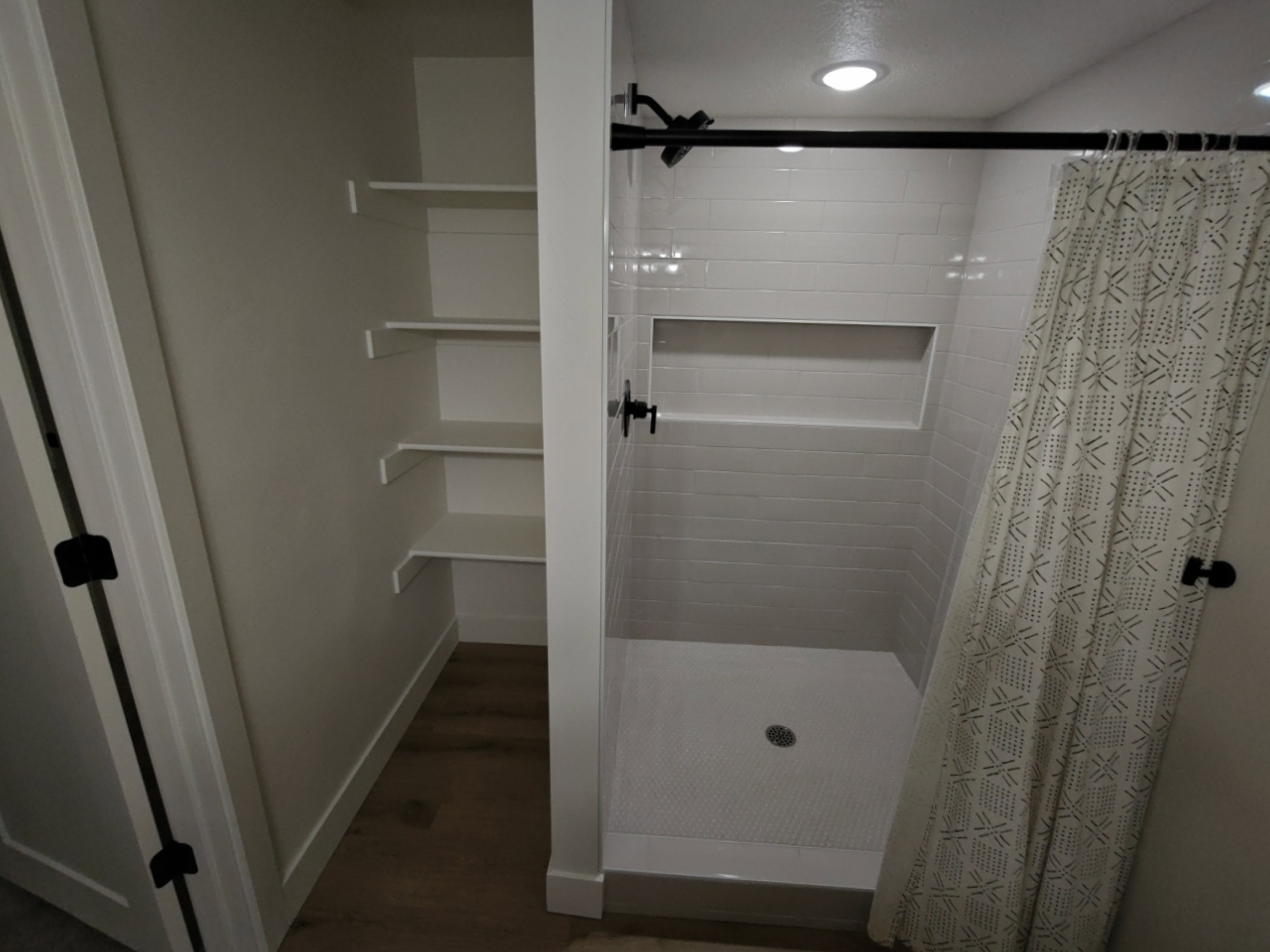 Contemporary shower featuring subway tile surround and a recessed niche