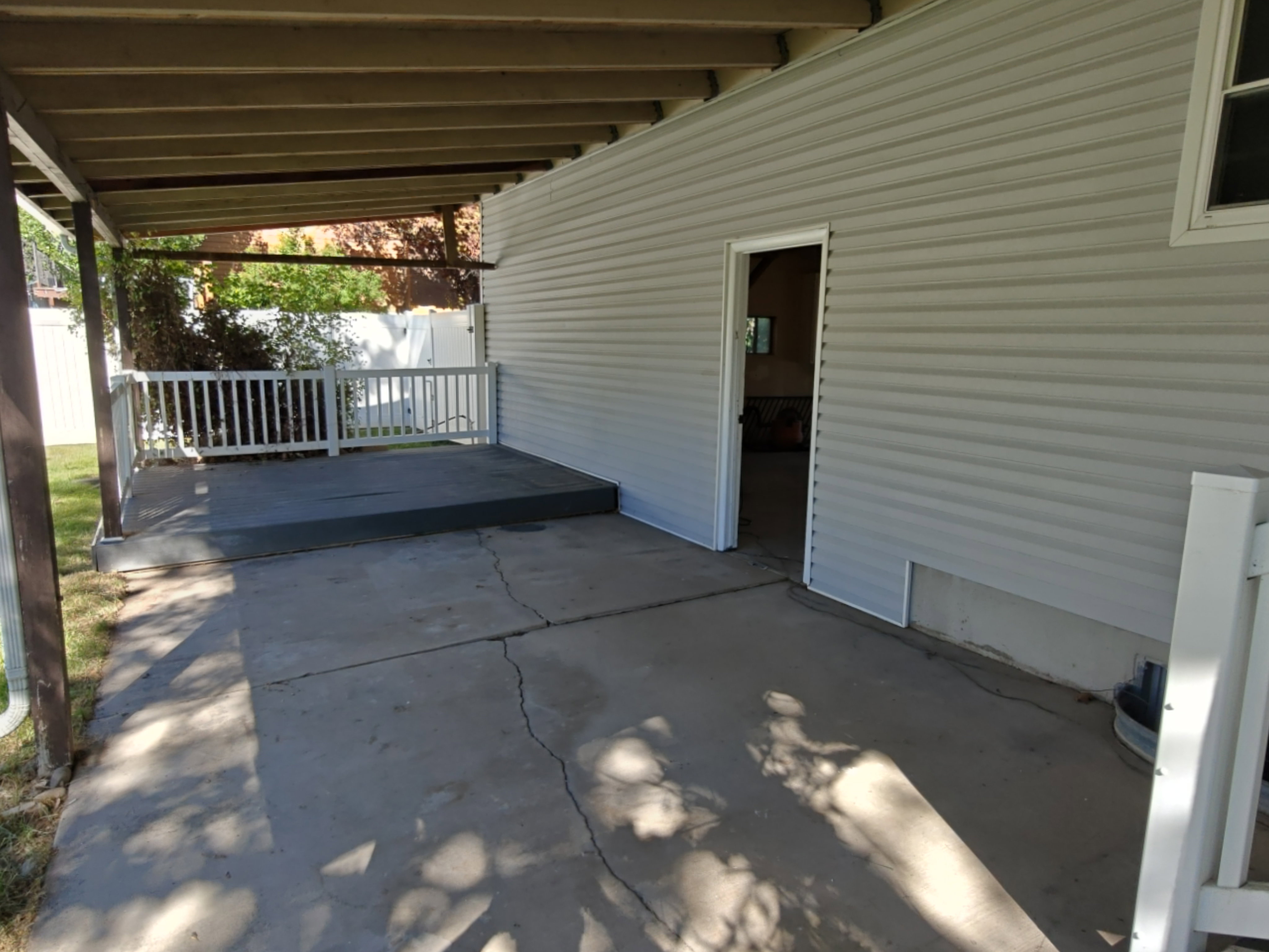 Covered patio area featuring a concrete surface and wood-toned ceiling beams