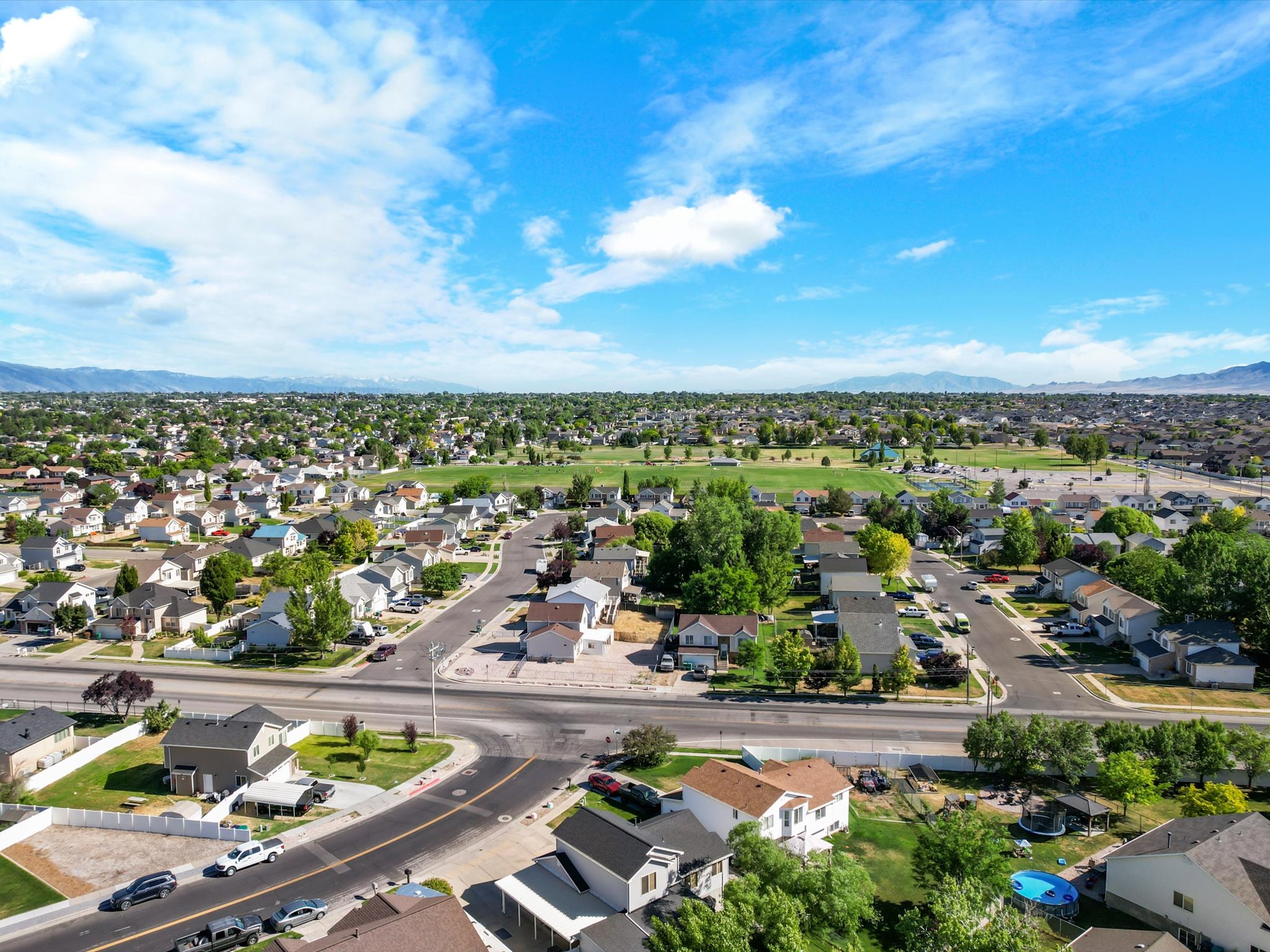 Aerial perspective showcasing a residential neighborhood with a large central green space